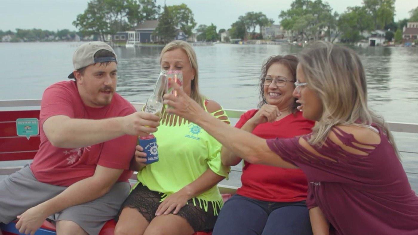 Guests raising their cans in a cheers at the bar